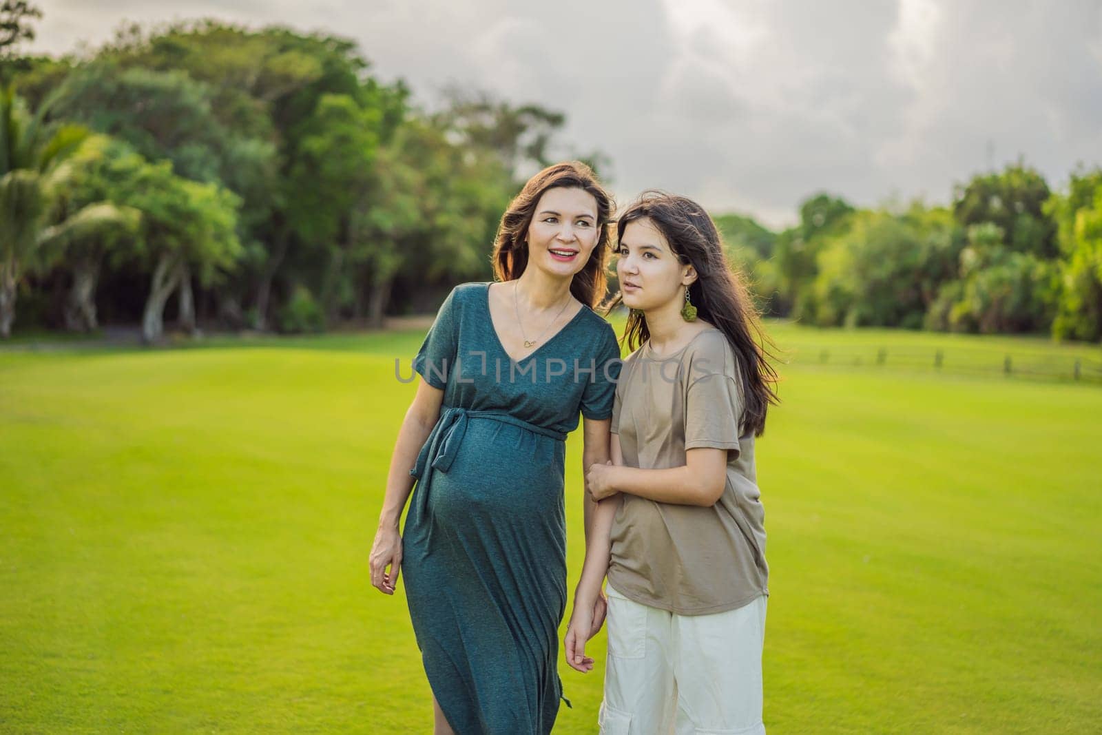 A heartwarming moment captured in the park as a pregnant woman after 40 shares a special bond with her teenage daughter, embracing the beauty of mother-daughter connection.