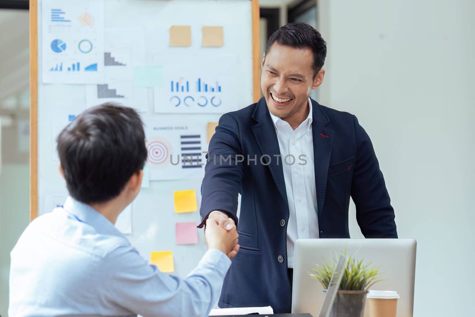 Handshake of employees after successful planning strategy marketing in the office.