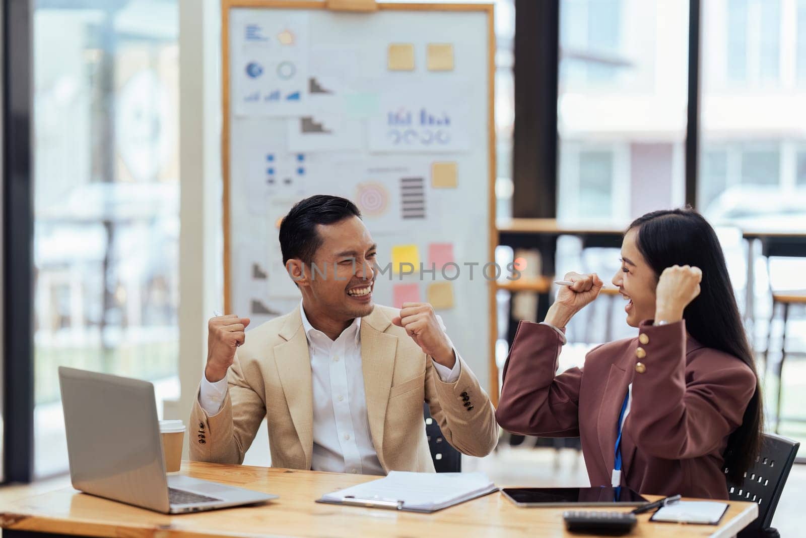 Businesspeople smile and raise hands up, feeling celebrate after project or agreement success with colleague.