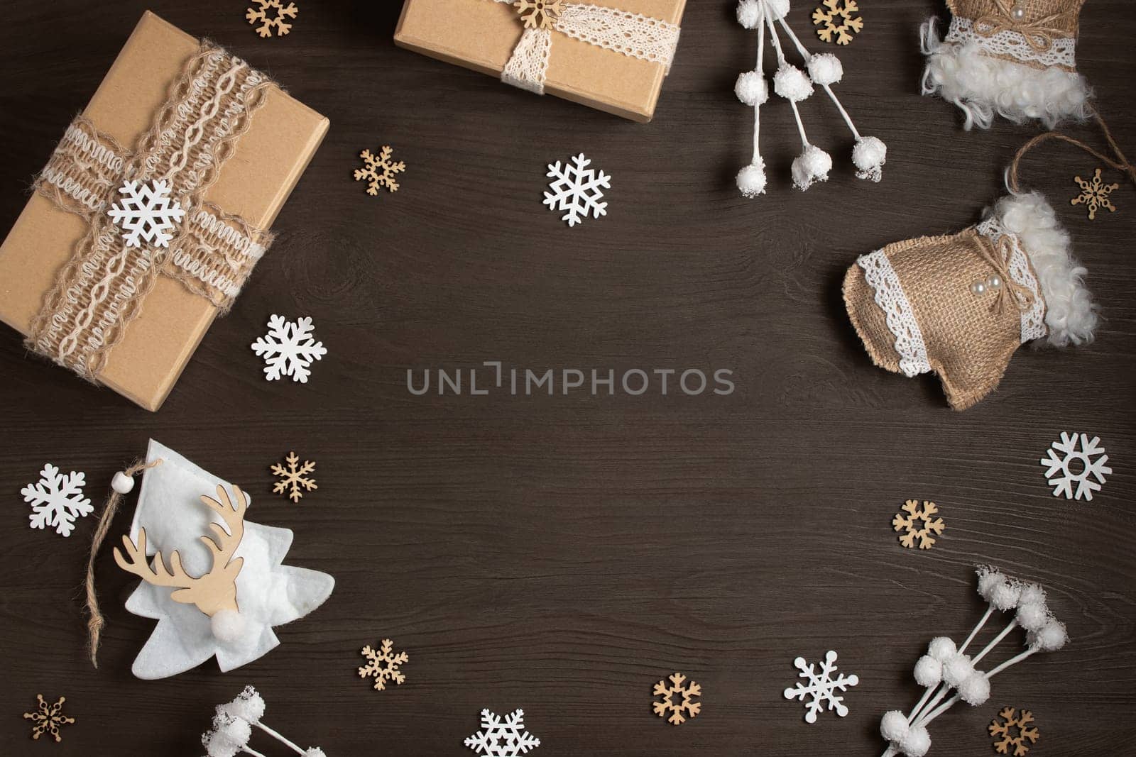 Christmas gifts and decorations made of natural materials on a dark wooden table with a copy space. Mockup for cards and advertisements.