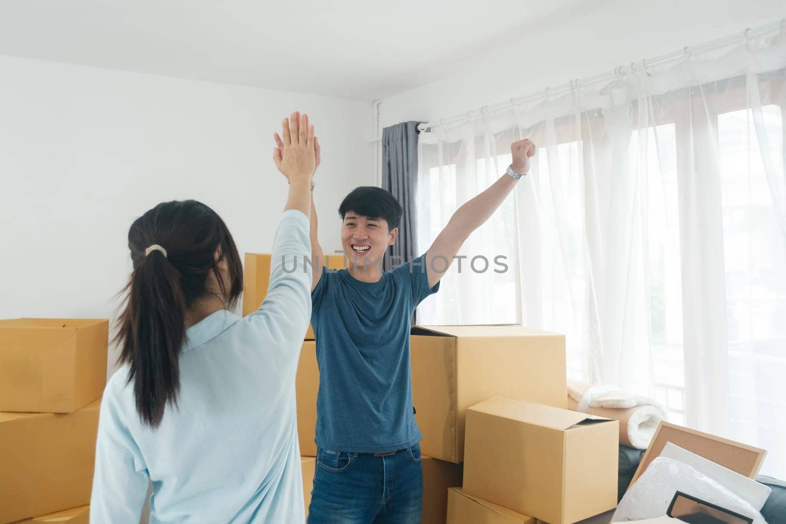Happy couple with cardboard boxes in new house at moving day. New house owner and real estate concept.