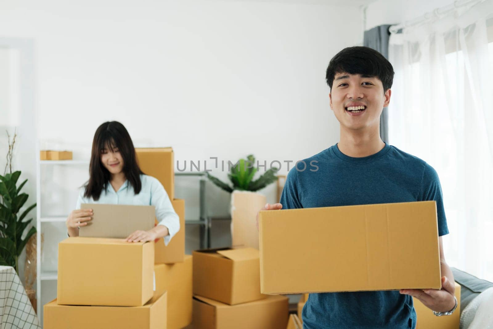 Happy young couple with cardboard boxes in their new home. by ijeab