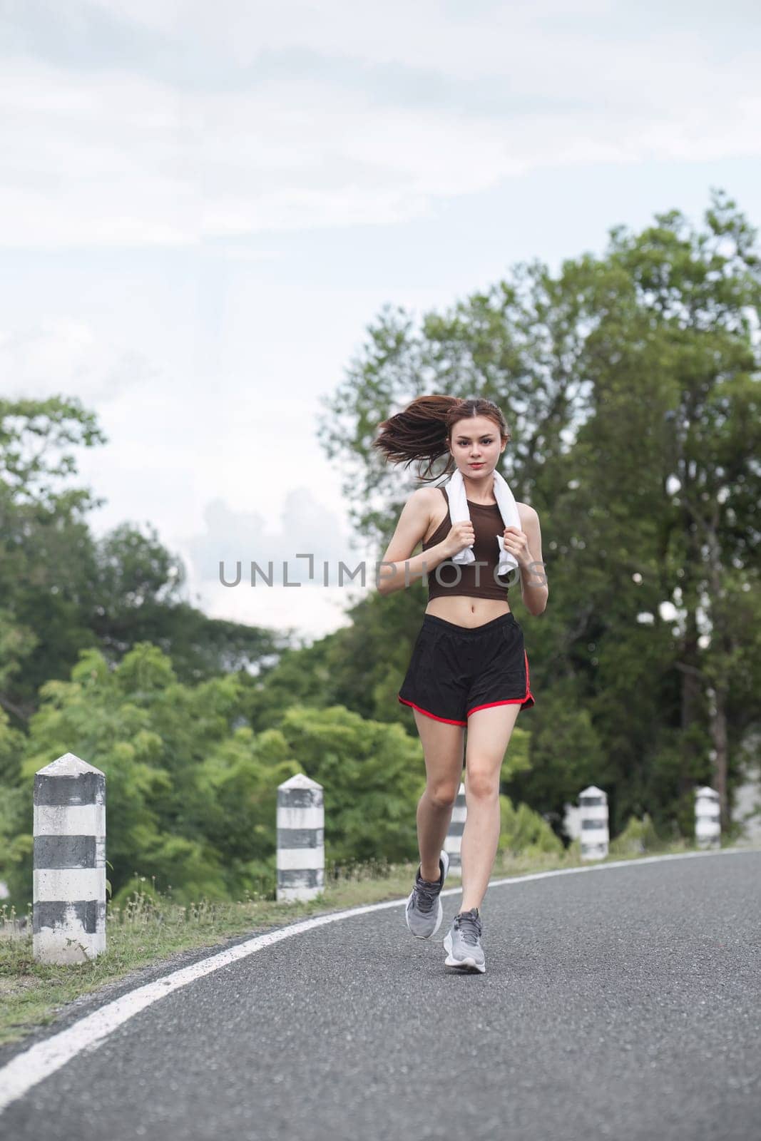 Young sporty woman jogging in the green park in the evening.