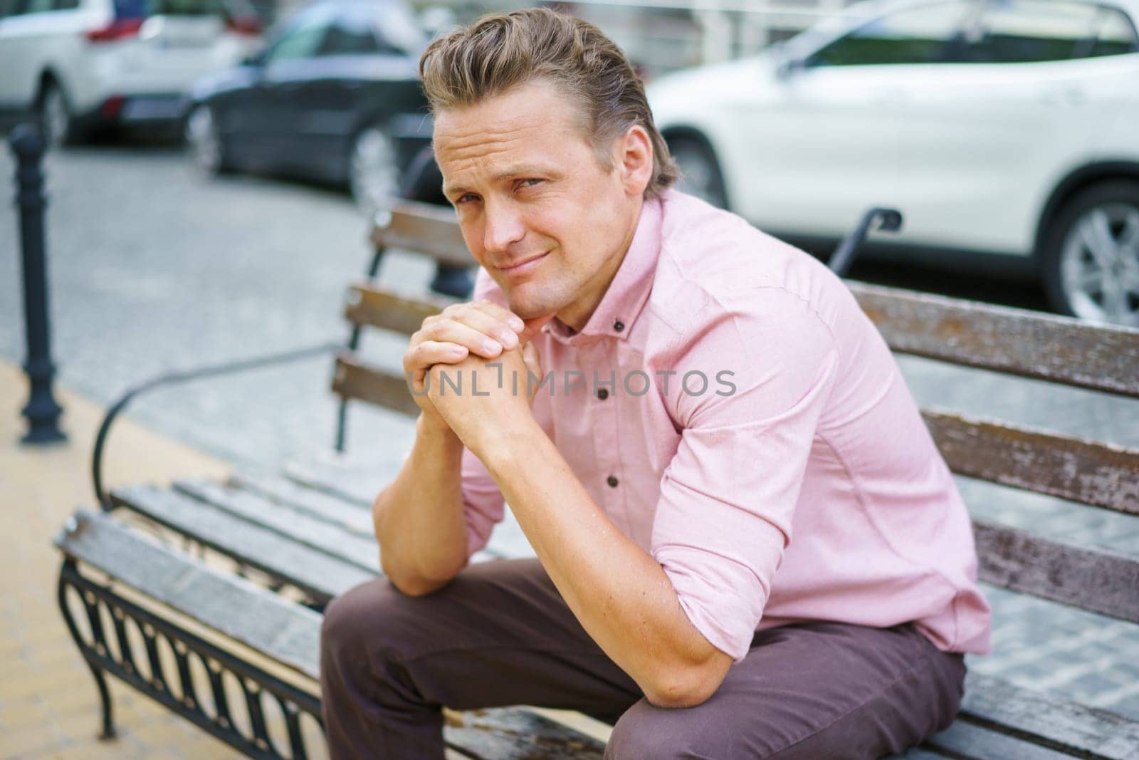 Successful person finding moment of respite. Man sits thoughtfully on bench, away from urban chaos, engrossed in deep contemplation. . High quality photo