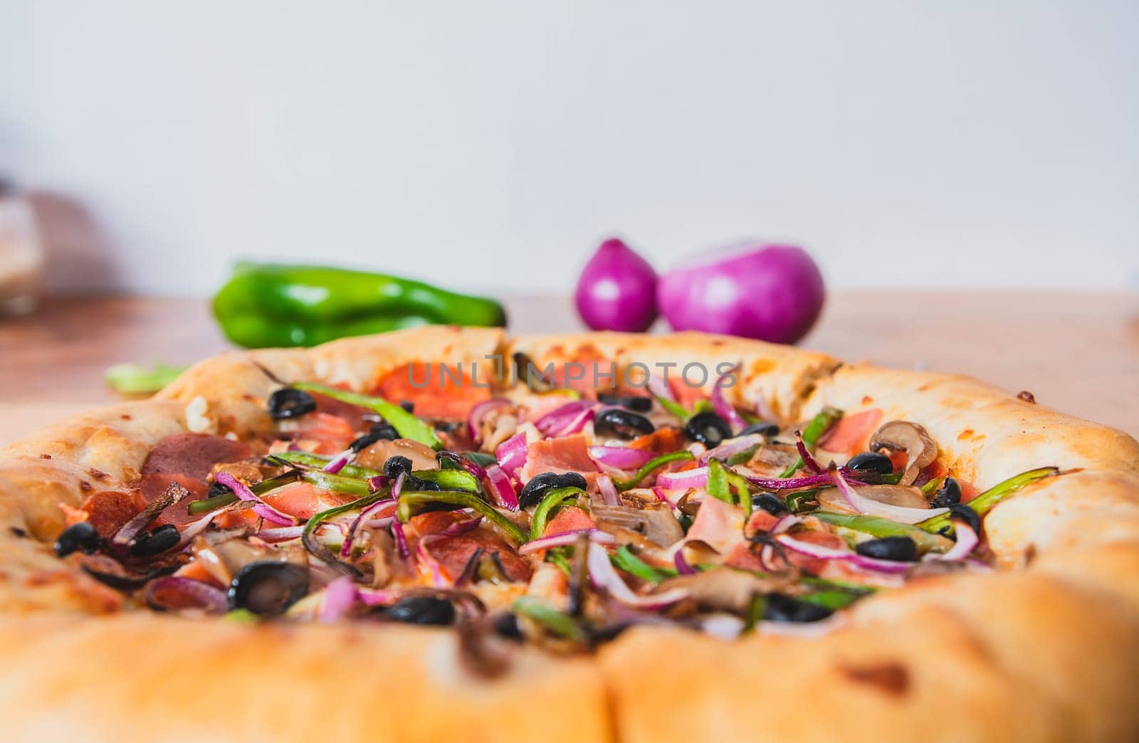 Supreme pizza with olives and vegetables on wooden table with space for text. Delicious supreme pizza with vegetables served on table by isaiphoto