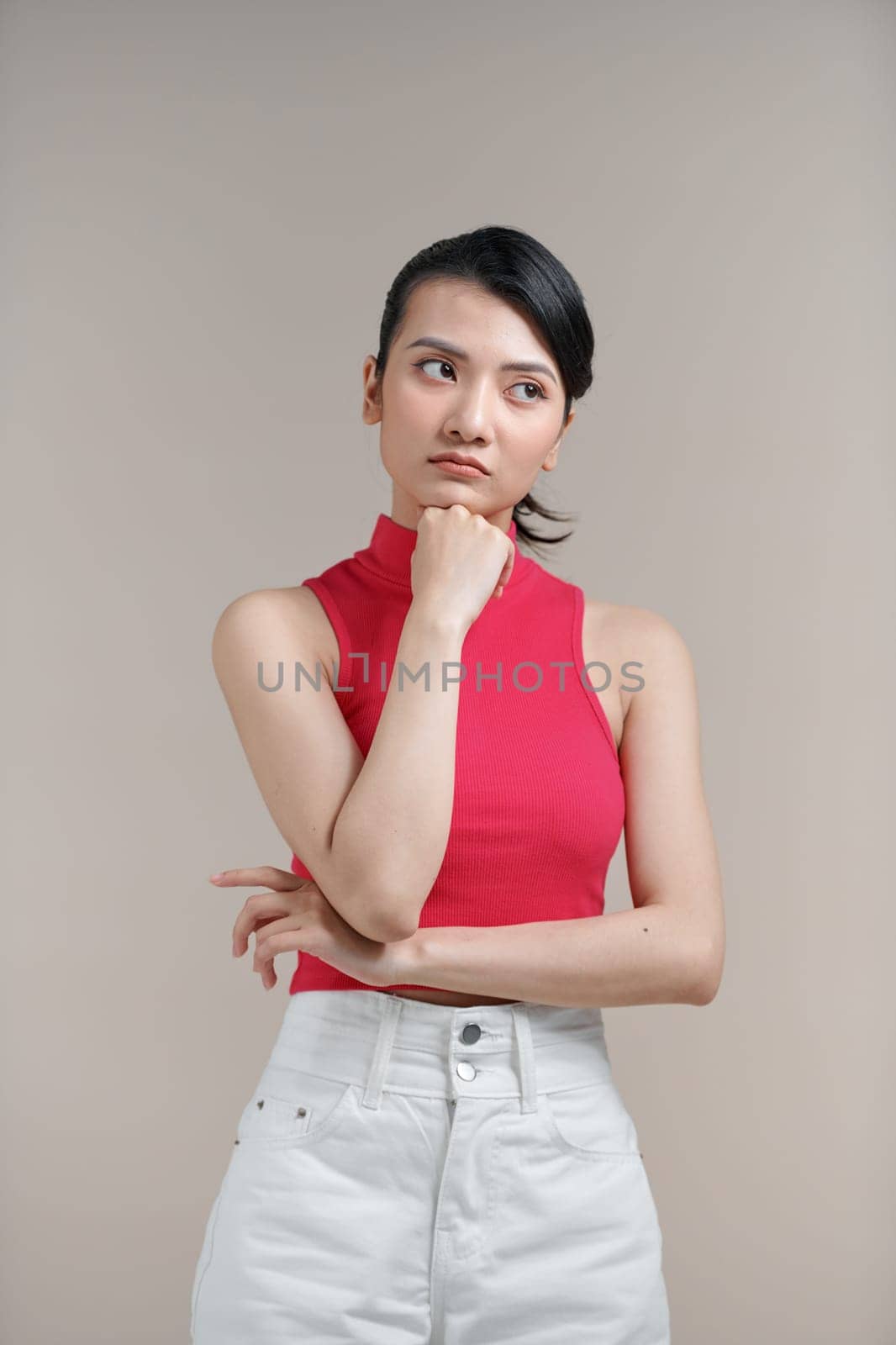 Asian woman thinking and looking to empty isolated on beige background by makidotvn