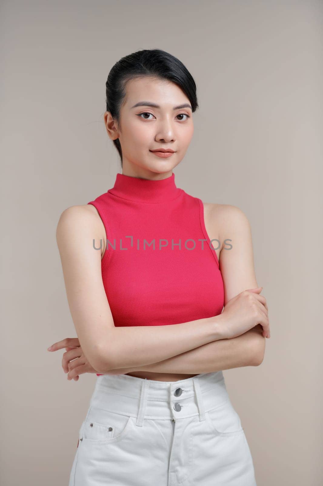 Young asian woman frowning face in displeasure, keeps arms folded