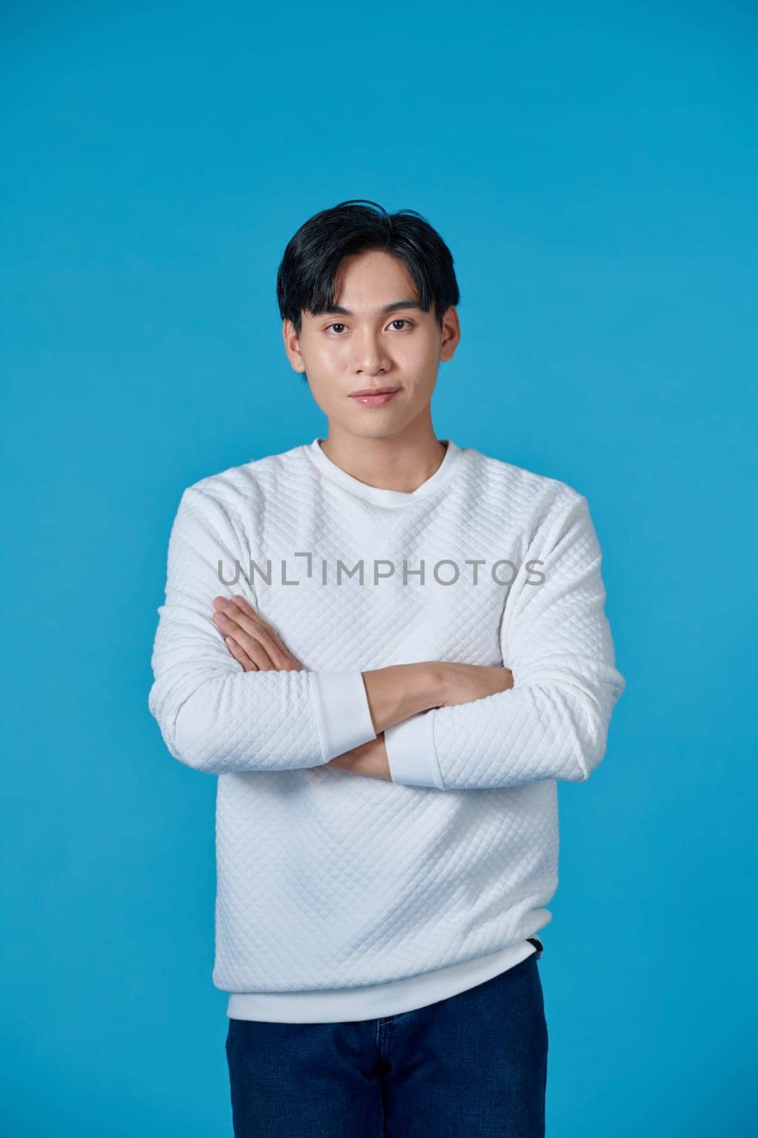 Young asian man posing on a blue background