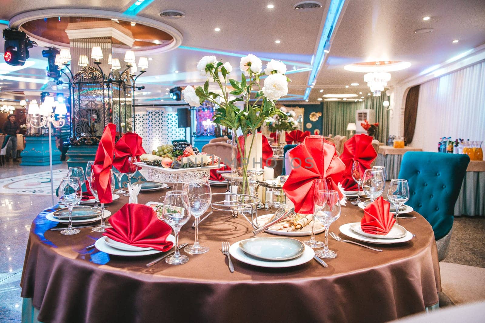 a set table with dishes and red napkins for the holiday in a beautiful restaurant