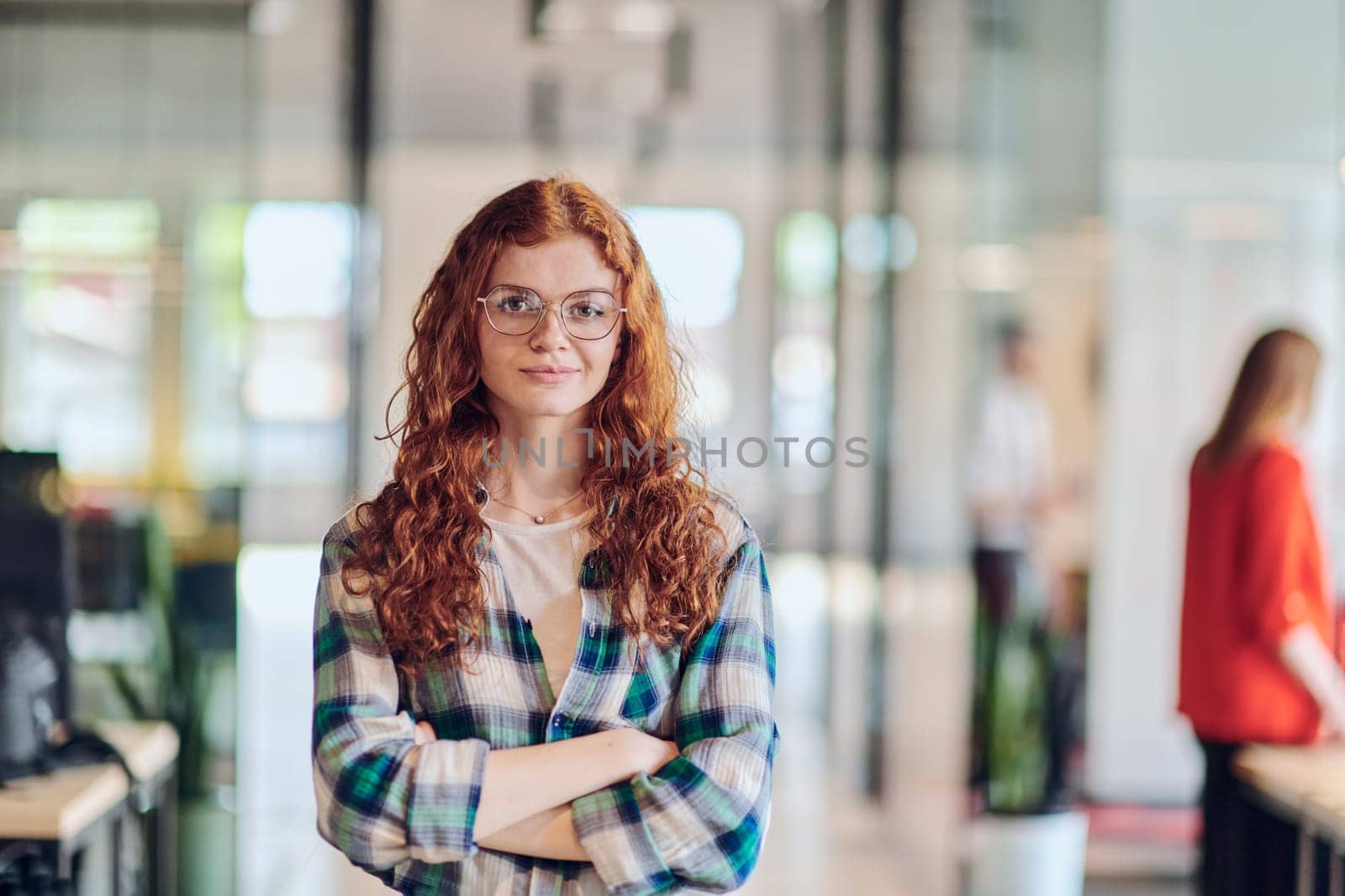 A portrait of a young businesswoman with modern orange hair captures her poised presence in a hallway of a contemporary startup coworking center, embodying individuality and professional confidence