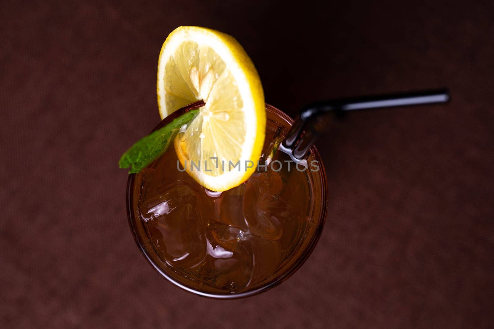 top view cold alcoholic drink with ice and a slice of lemon in a glass glass with a straw by Pukhovskiy