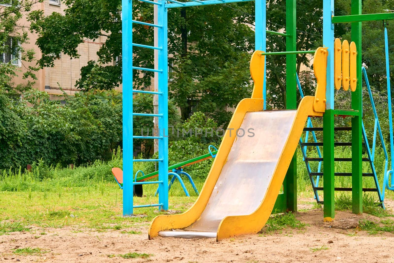 Summer spring children's playground with painted toy slide in park by jovani68