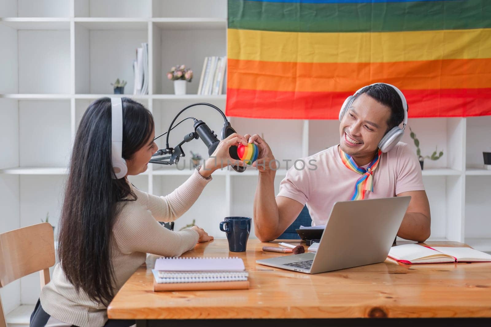 Men and women hold rainbow hearts, a symbol of the LGBT community, in support of gender equality. by wichayada