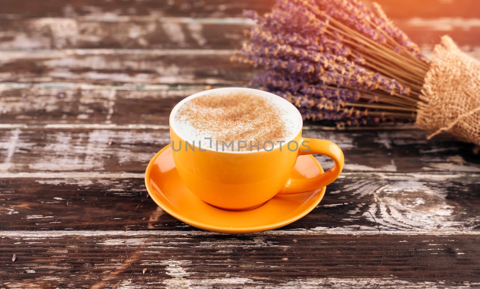 yellow latte coffee cup and lavender bouquet on wooden background