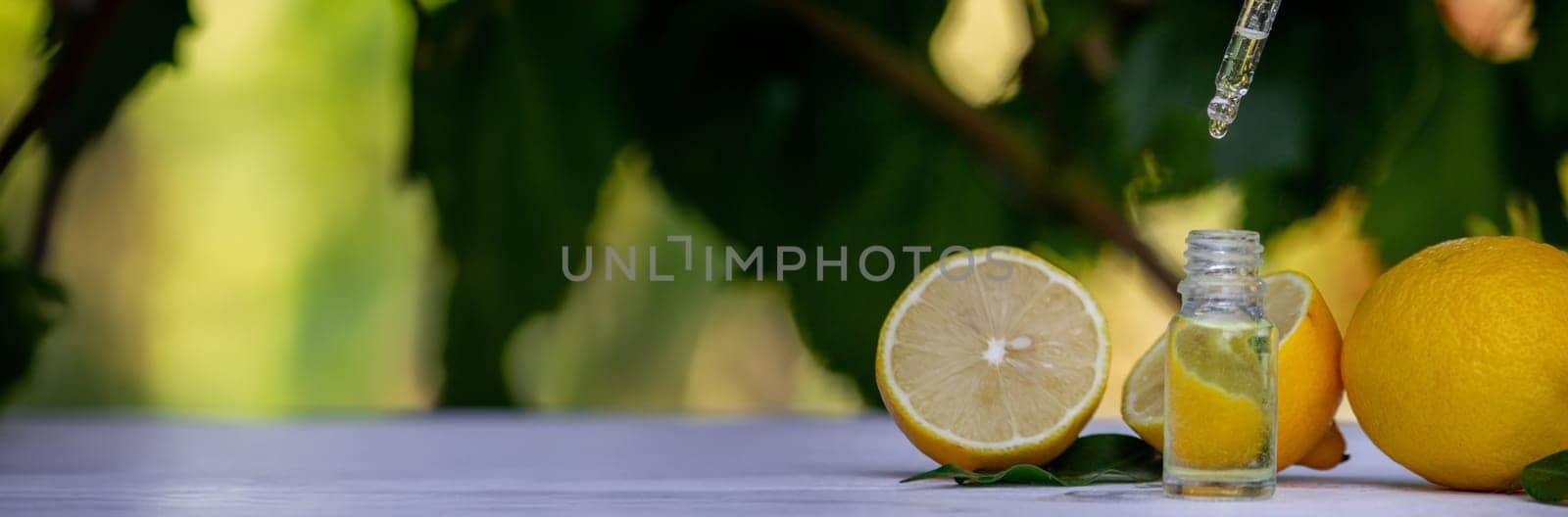 lemon essential oil and lemon fruit on a wooden white board. Selective focus