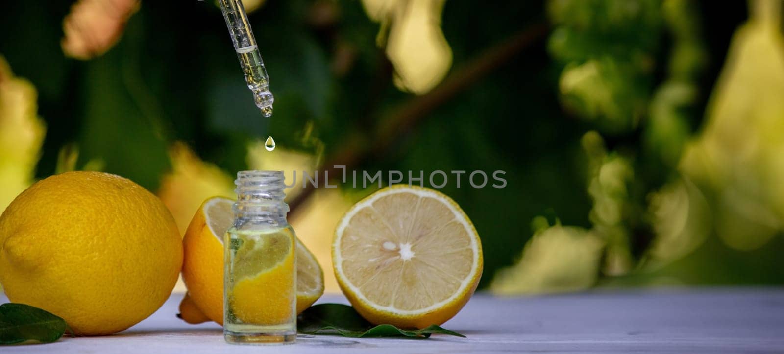 lemon essential oil and lemon fruit on a wooden white board. Selective focus