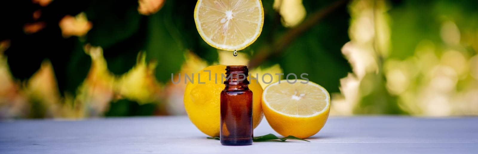 lemon essential oil and lemon fruit on a wooden white board. Selective focus