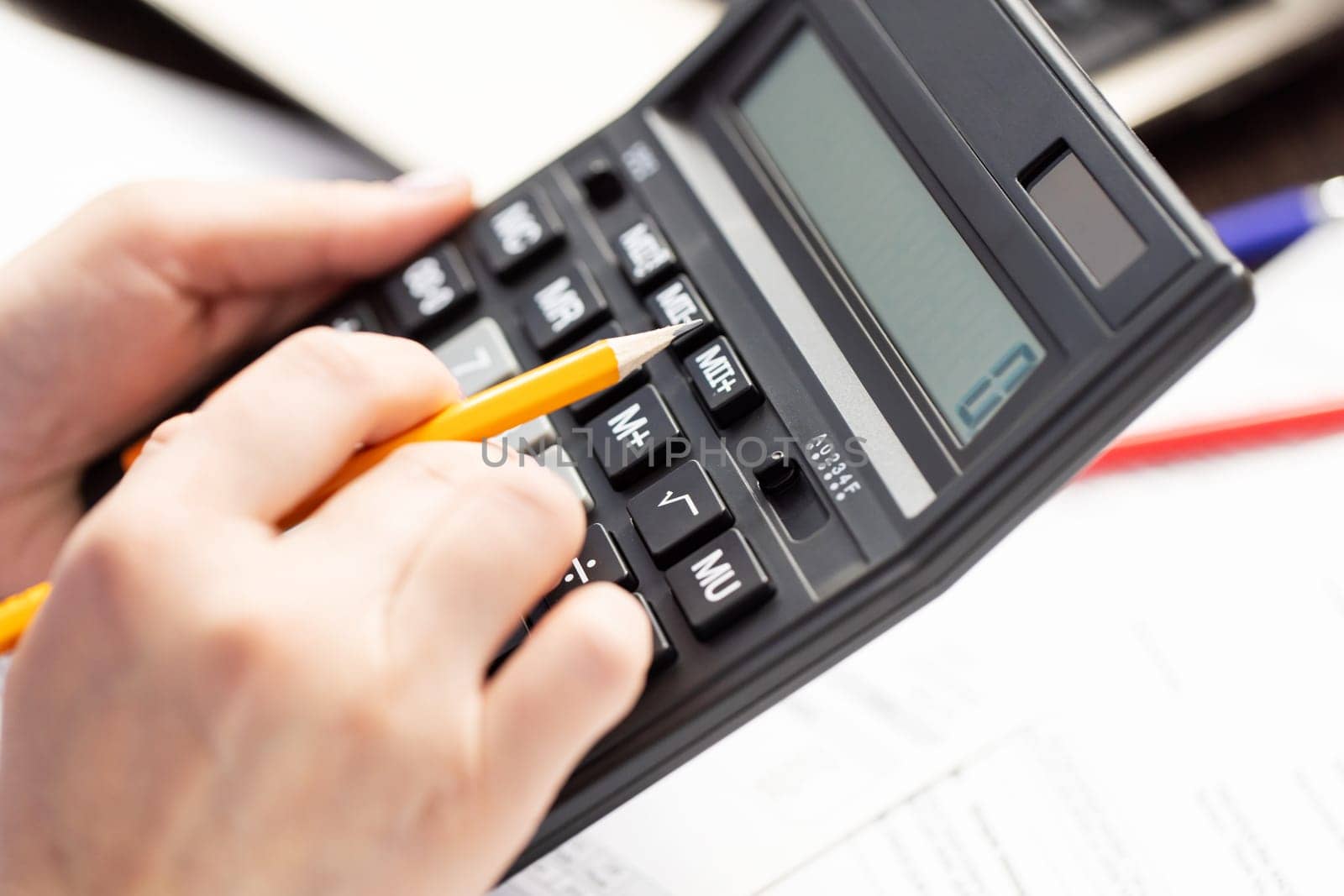 Woman managing household family expenses using calculator, calculating household finances or car taxes.