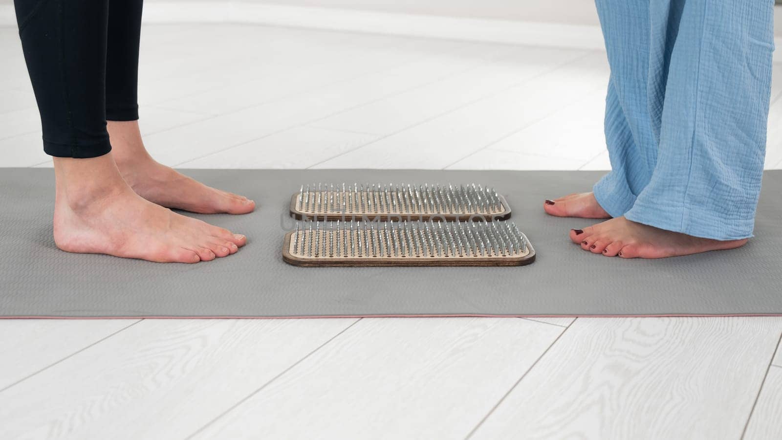 Female feet next to sadhu boards in yoga studio. by mrwed54