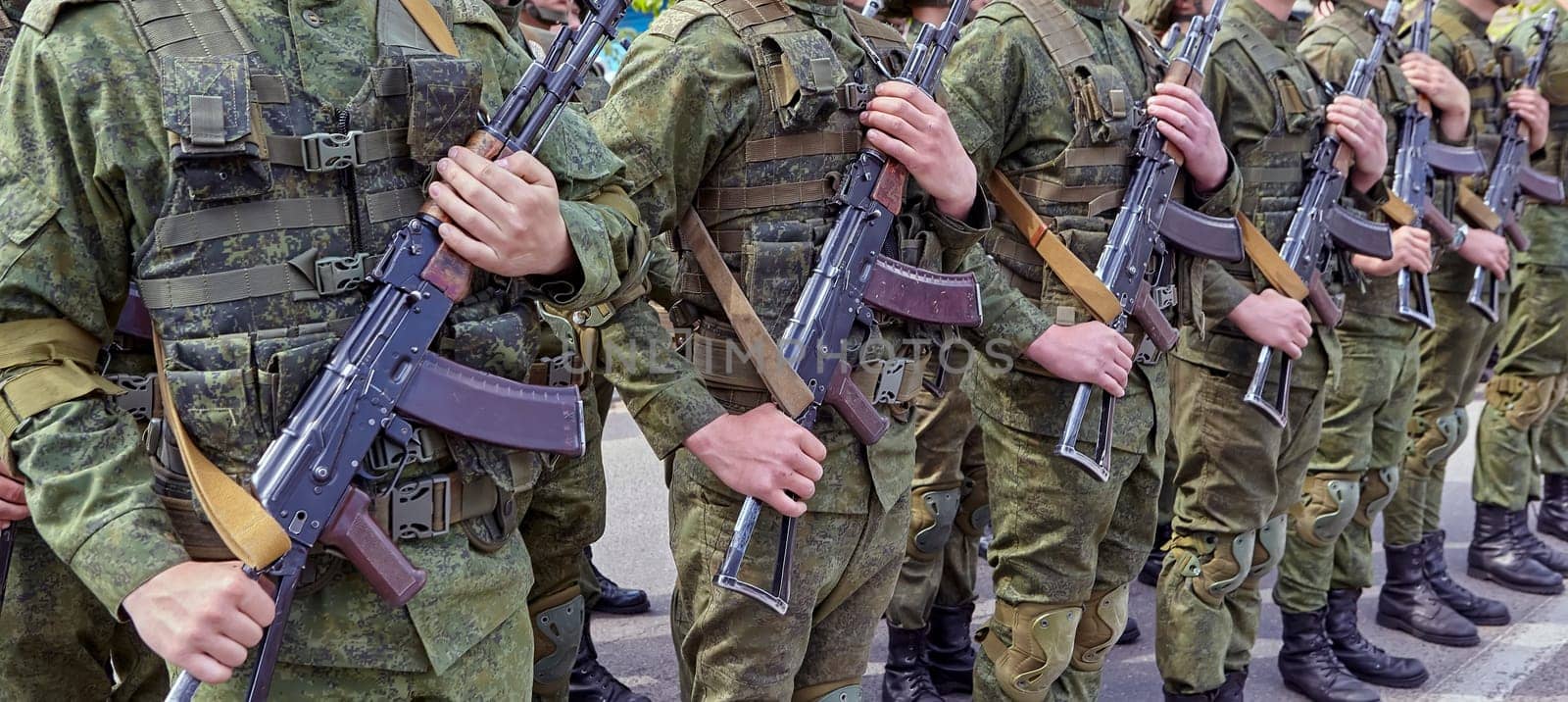 Soldiers stand in line with rifles. Soldiers shoulder to shoulder during the parade.