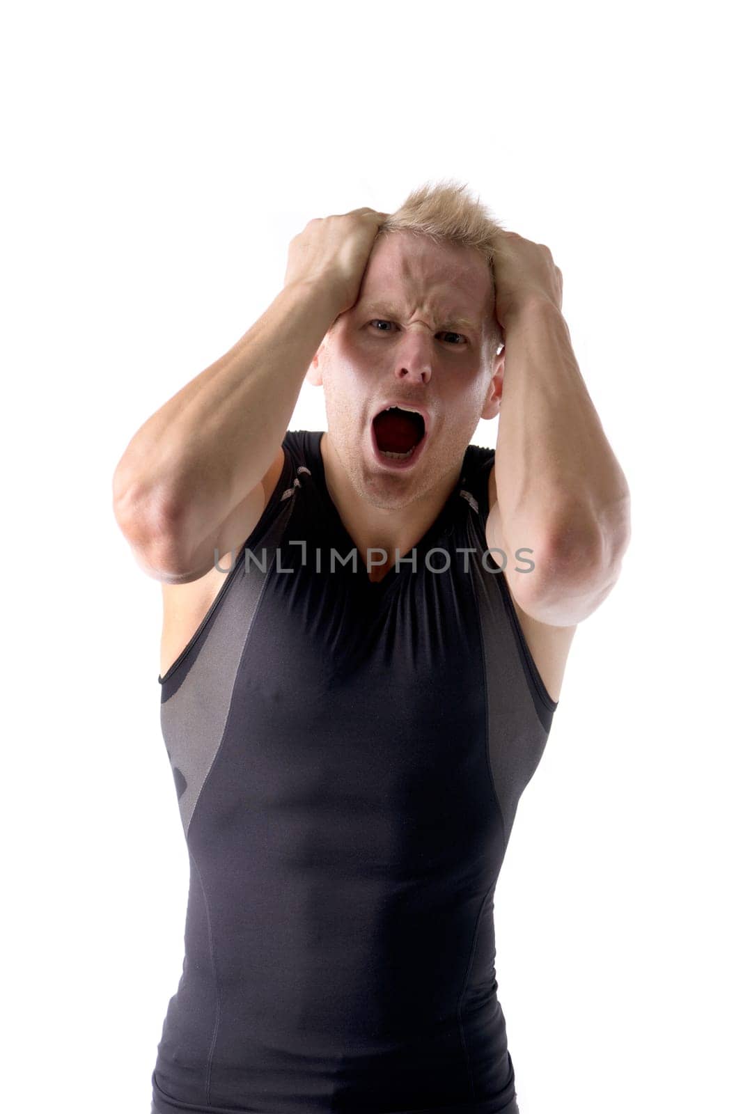 A man in a black shirt holding his hands up to his ears, expressing desperation or anger