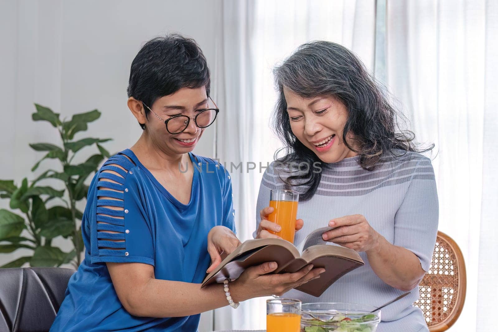 Two 60s woman enjoys talking with her friends and having a healthy food together..