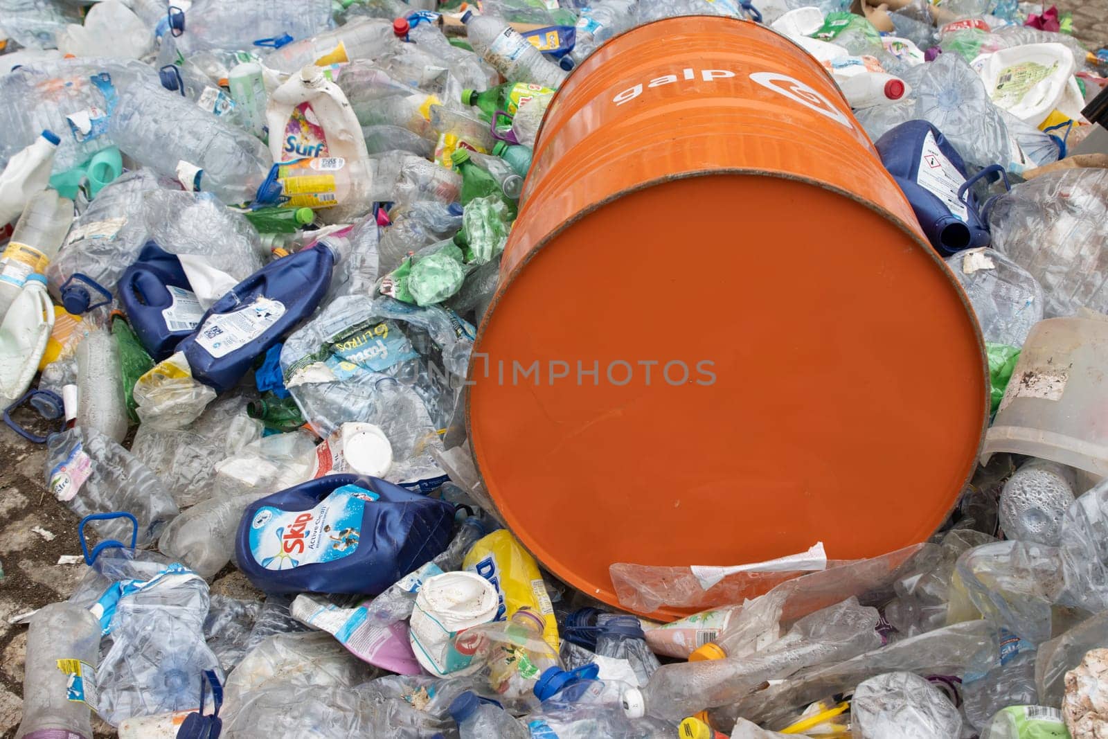 16 october 2022 Almada, Portugal: GALP orange barrel laying on top of landfill of plastic garbage. Mid shot