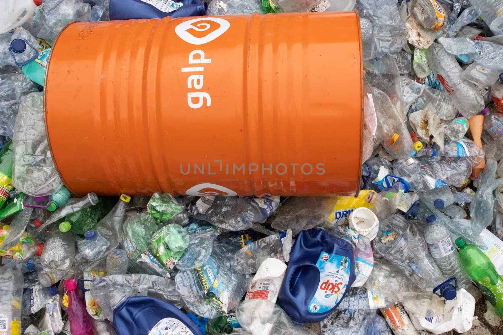 16 october 2022 Almada, Portugal: GALP orange barrel on the landfill full of plastic garbage. Mid shot