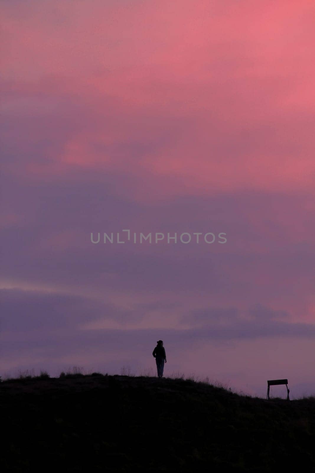 Silhouettes of people standing on the summit.