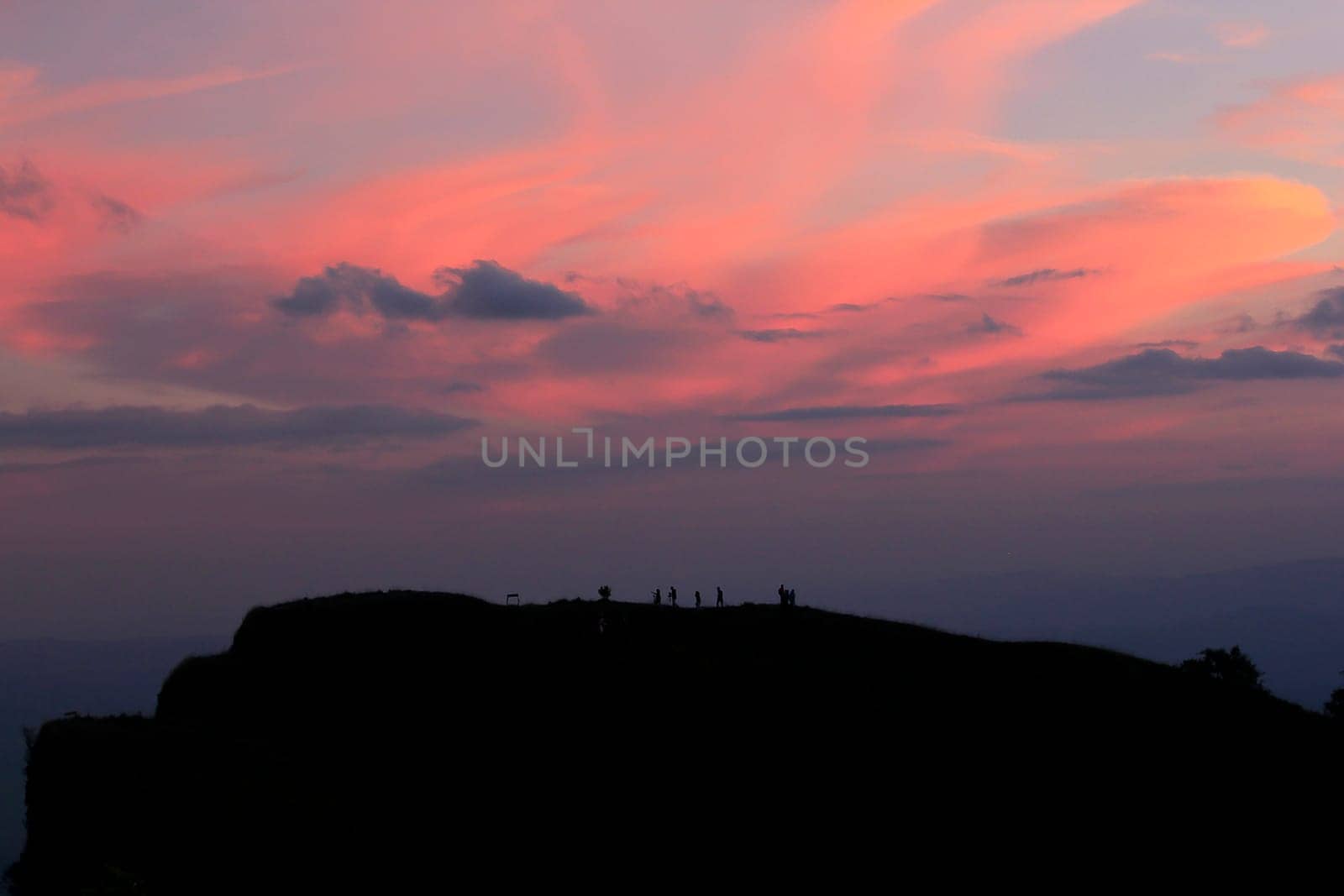 Silhouettes of people standing on the summit. by Puripatt