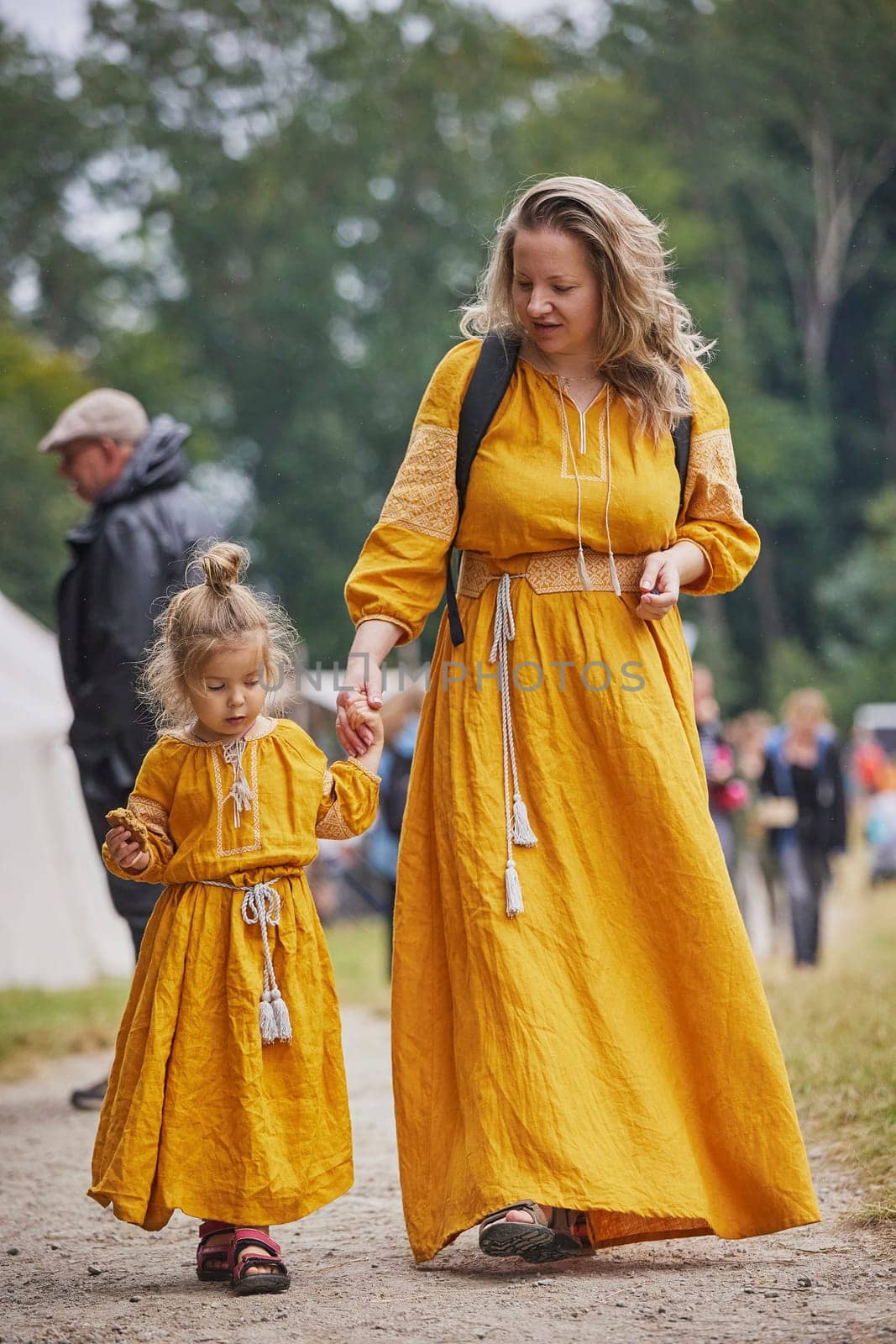 Beautiful woman with her daughter dressed in embroidered dresses.