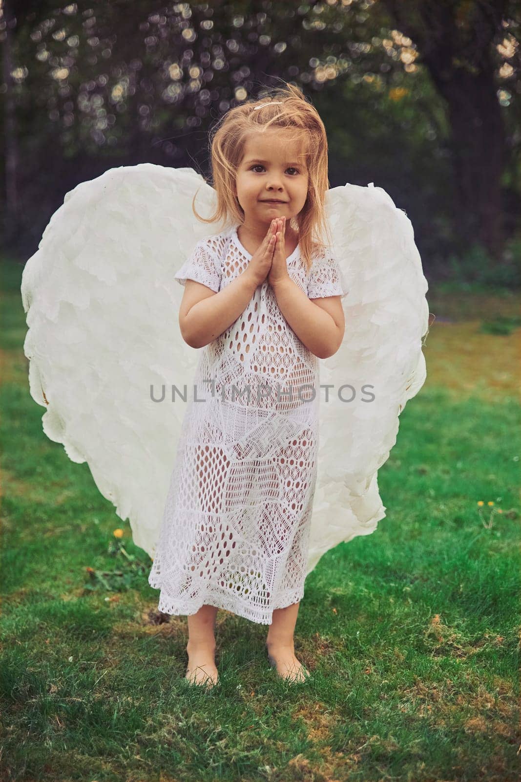 Cute baby dressed as an angel in the evening forest in Denmark.