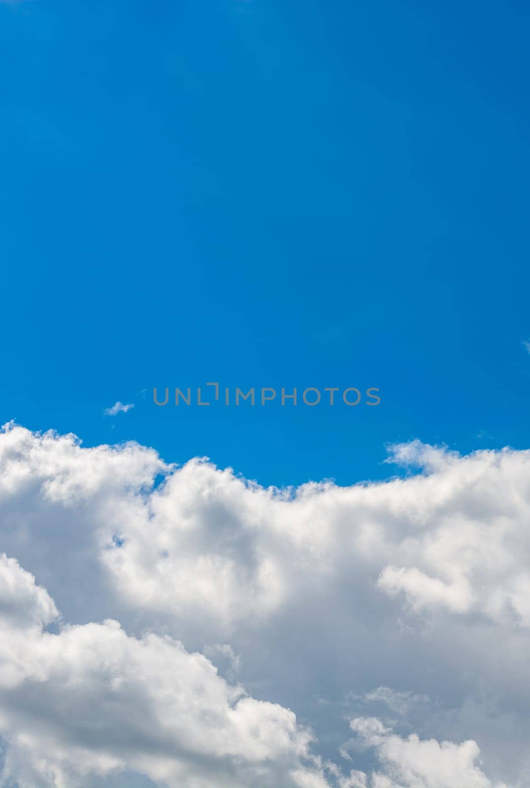 Vertical background bisected by white stratus clouds and blue sky