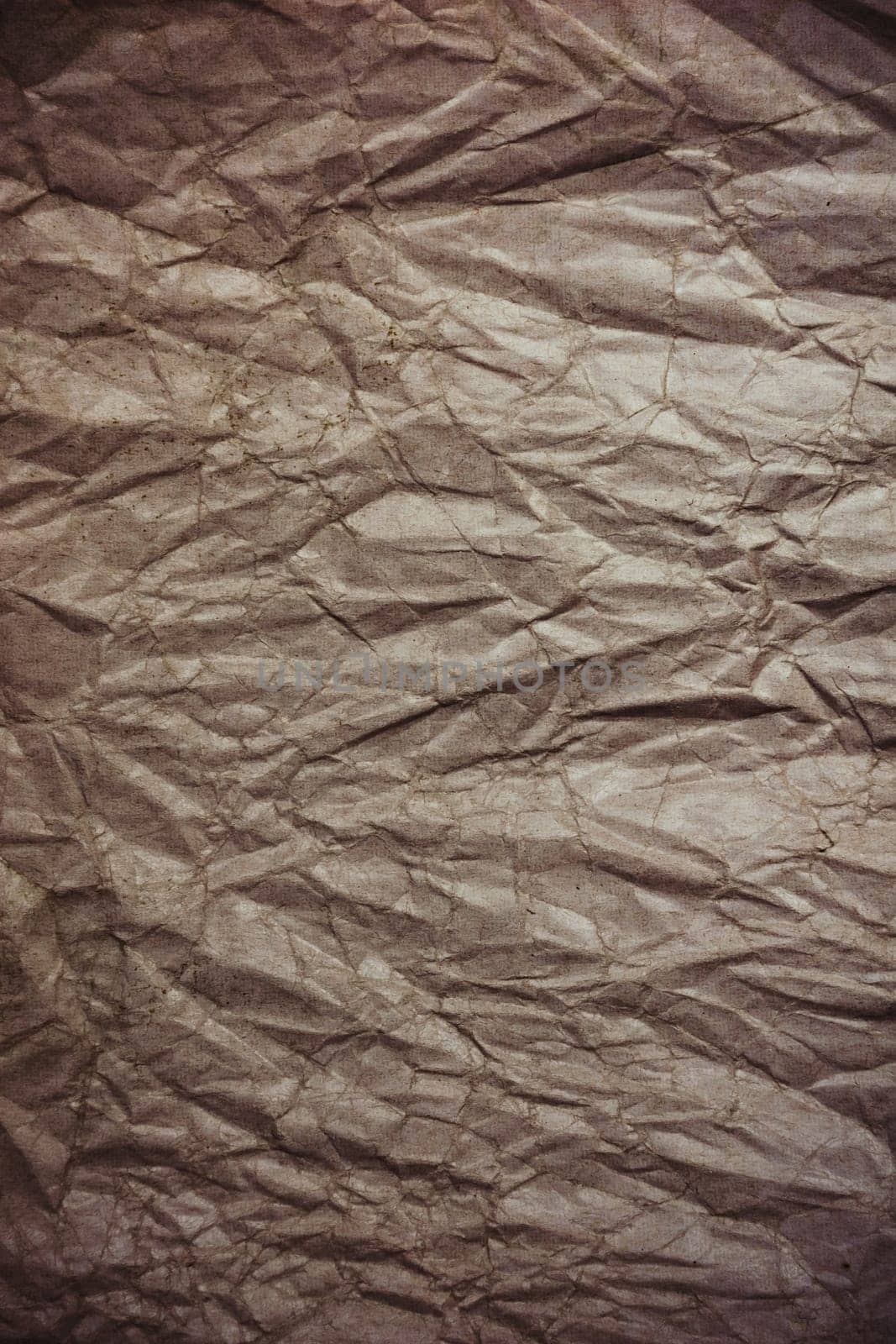 Crumpled cardboard from recycled paper with vignetting. Vertical background. Backdrop