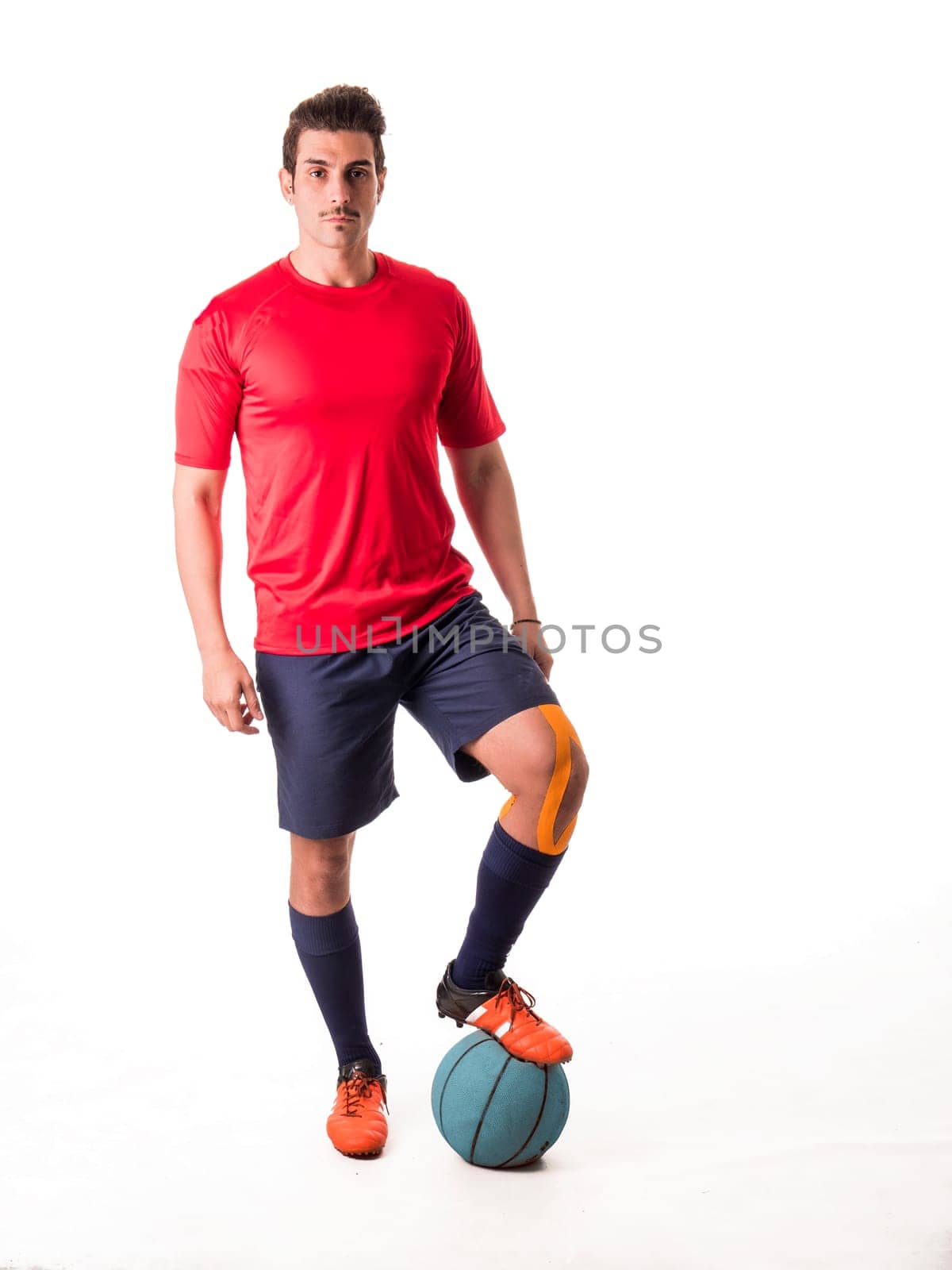 A man in a red shirt is standing next to a blue ball