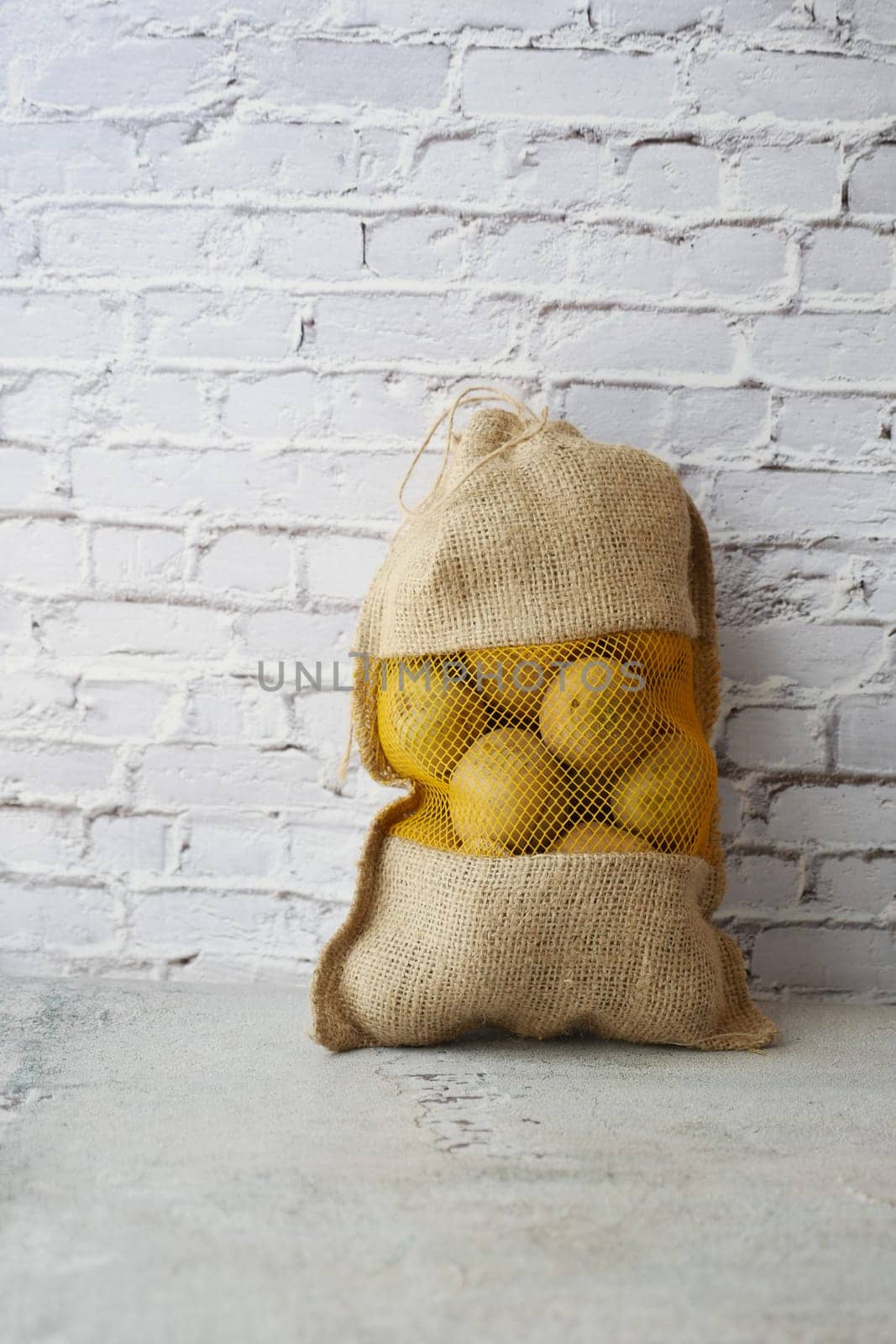 potatoes in a sack bag on table .