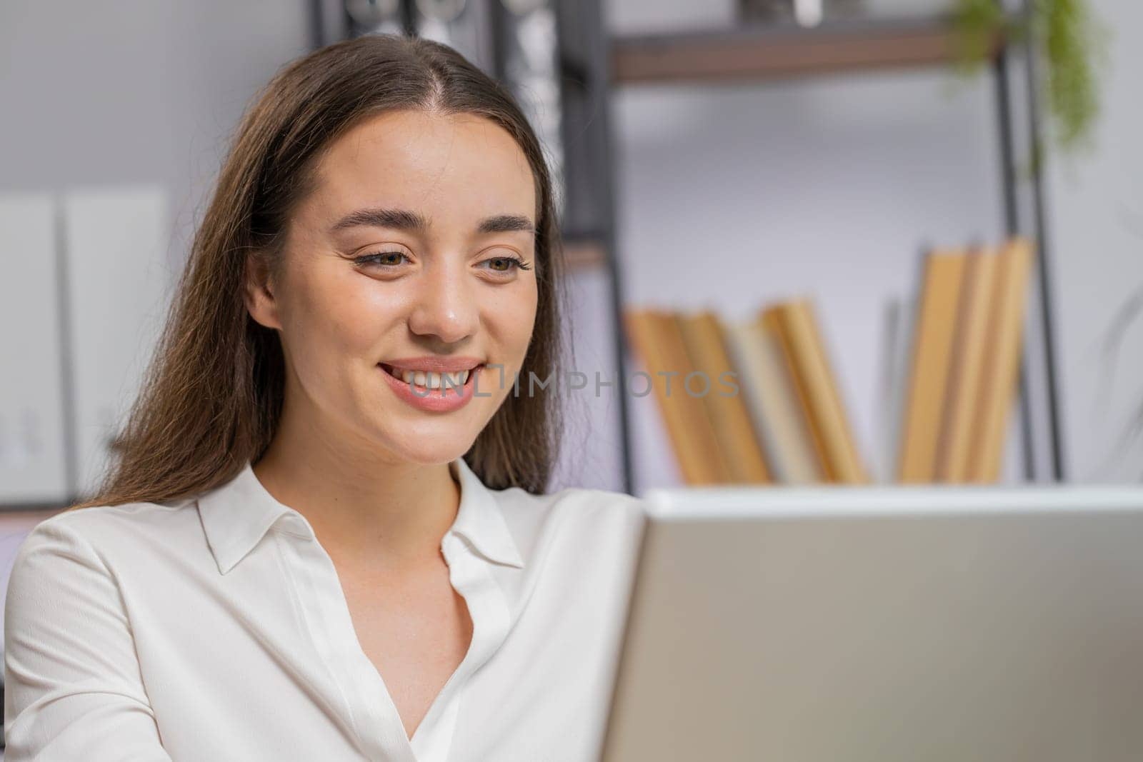 Close-up portrait Caucasian brunette business woman face freelancer at home office workplace working on laptop computer. Manager freelancer girl works on notebook send messages makes online purchases