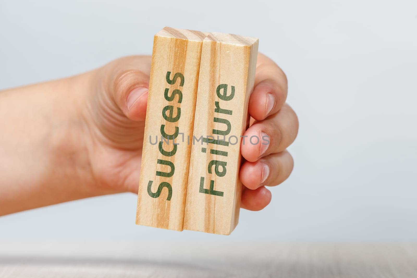 Success and failure. A hand holds two wooden cubes with the inscriptions SUCCESS and FAILURE For insertion into a design or project. by SERSOL