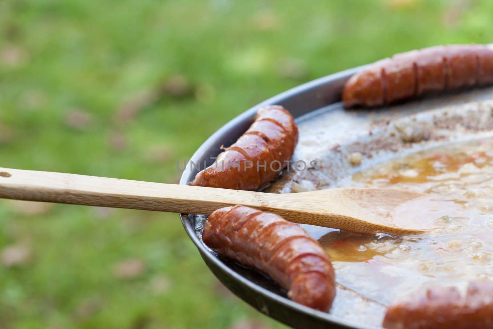 Baked sausages in traditional Croatian dish kotlovina.