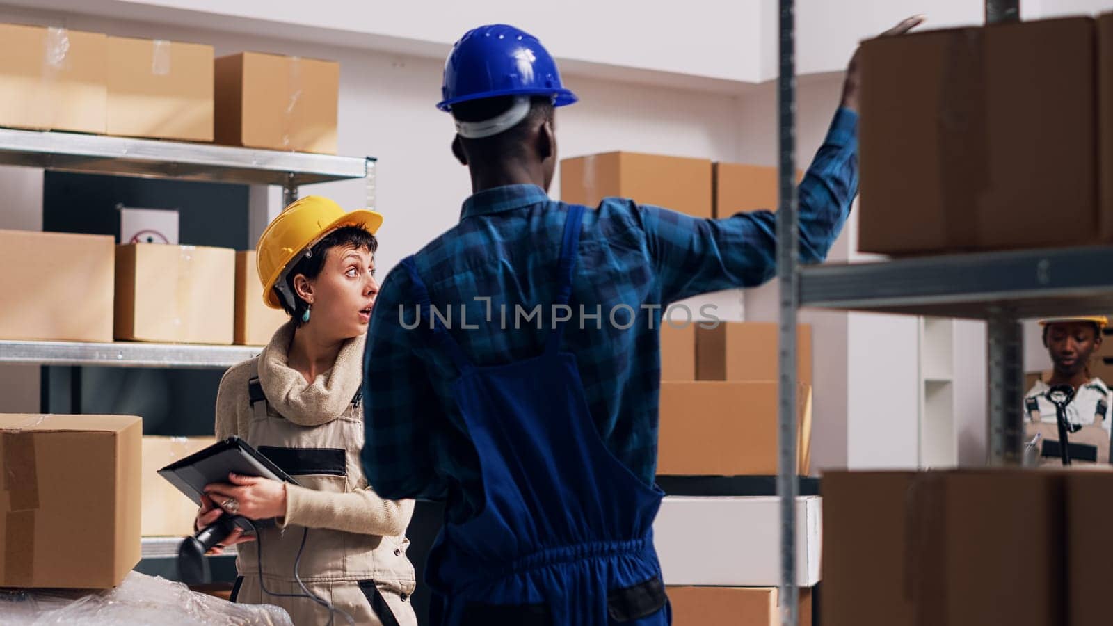 Man and woman scanning goods in warehouse depot, using digital tablet and scanner to scan barcodes and inventory for products. Team of workers planning stock logistics, industrial service.