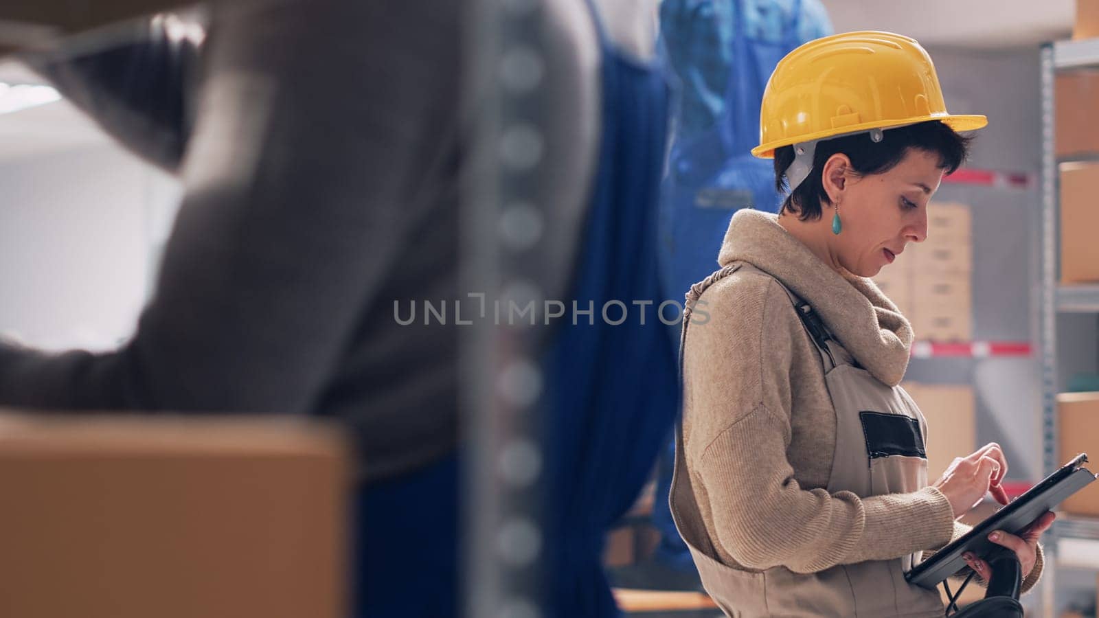 Young workers scanning products in storage room depot by DCStudio