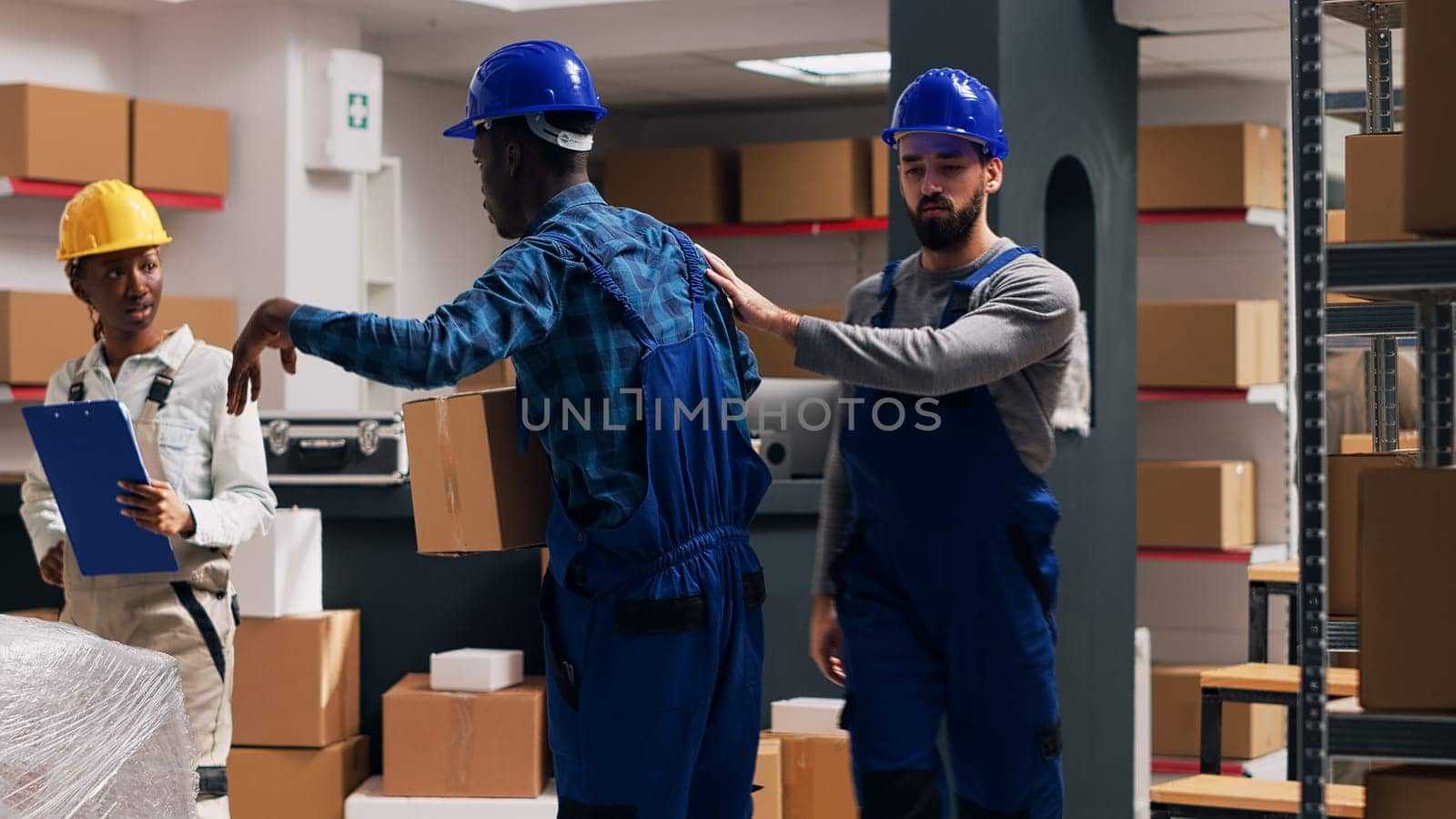 Multiethnic group of employees working with products in packages, planning shipment for goods distribution. Men and women looking at cardboard boxes filled with merchandise. Tripod shot.