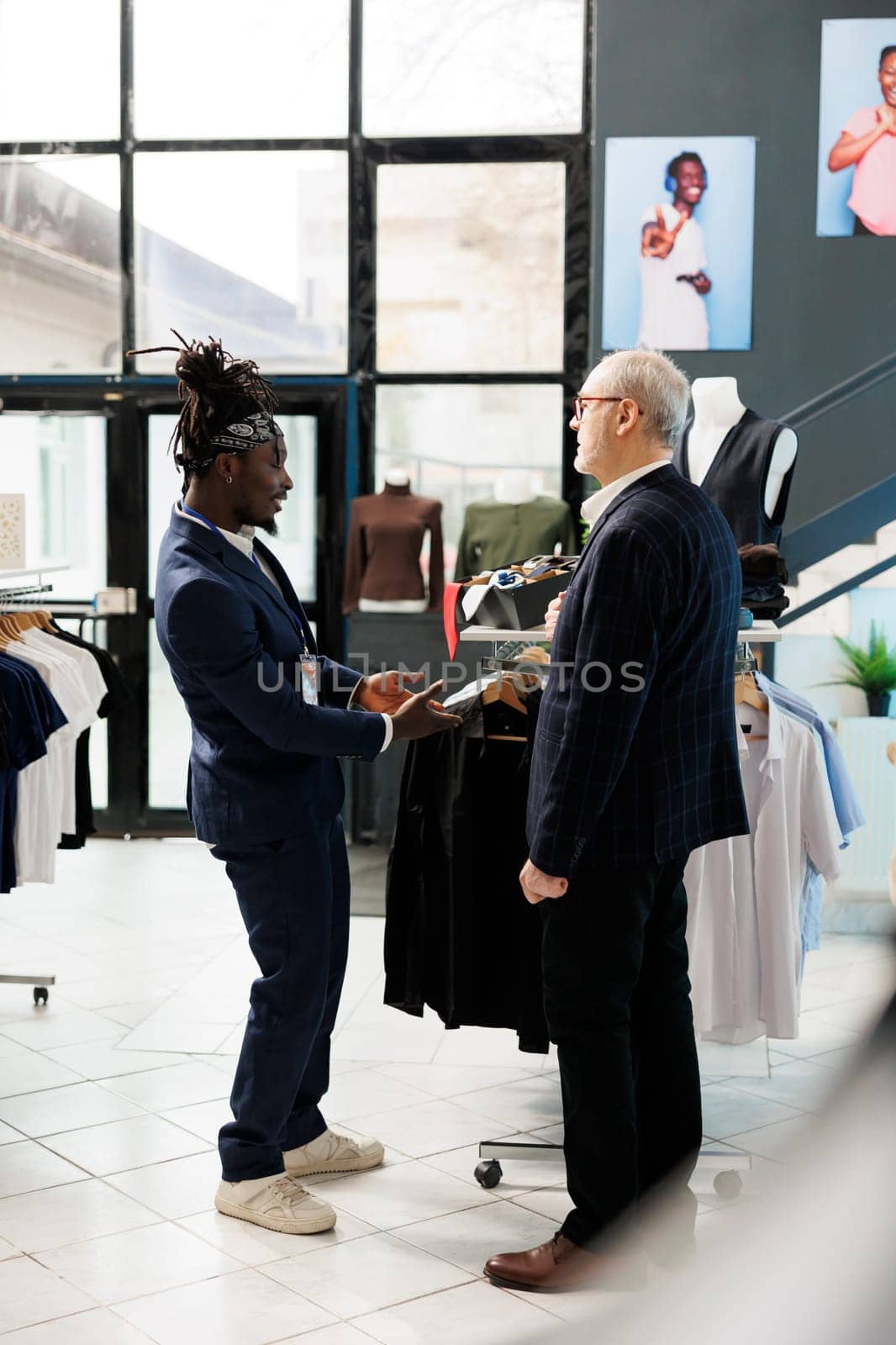 African american worker helping client with formal suit by DCStudio