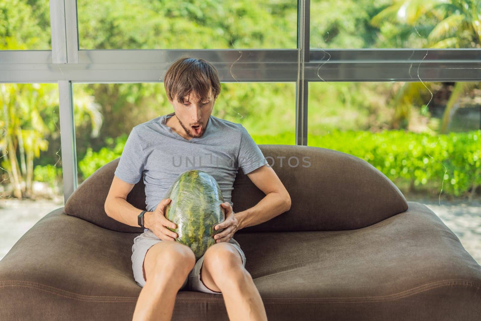 A humorous image: a pregnant woman and her husband playfully use a watermelon in place of a belly, comically highlighting the challenges of navigating with a pregnant bump.