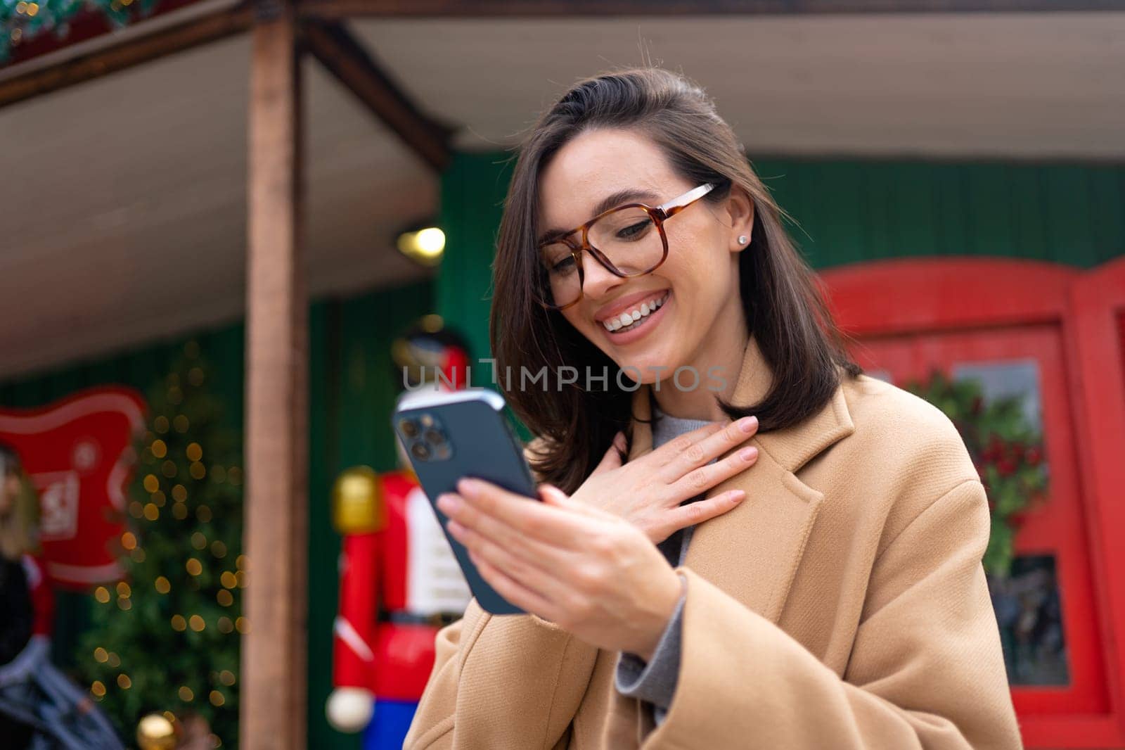 Happy, excited woman with smartphone outdoor by andreonegin