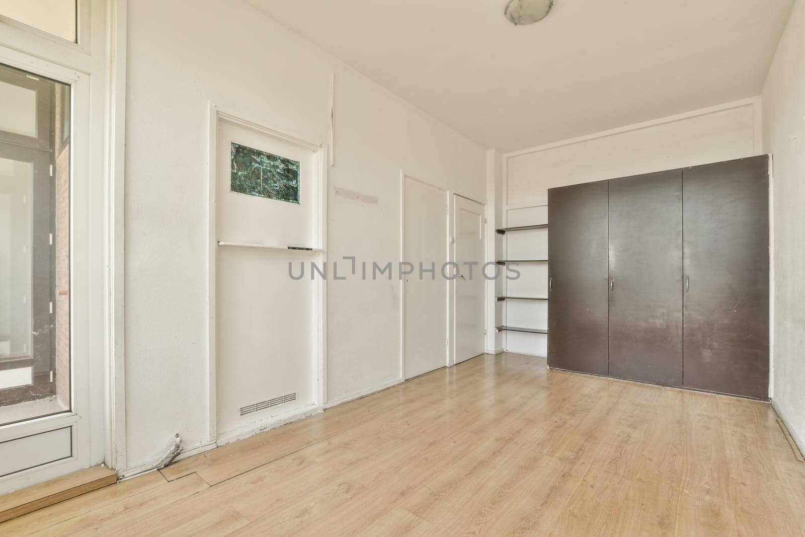 a living room with a wood floor and a closet by casamedia