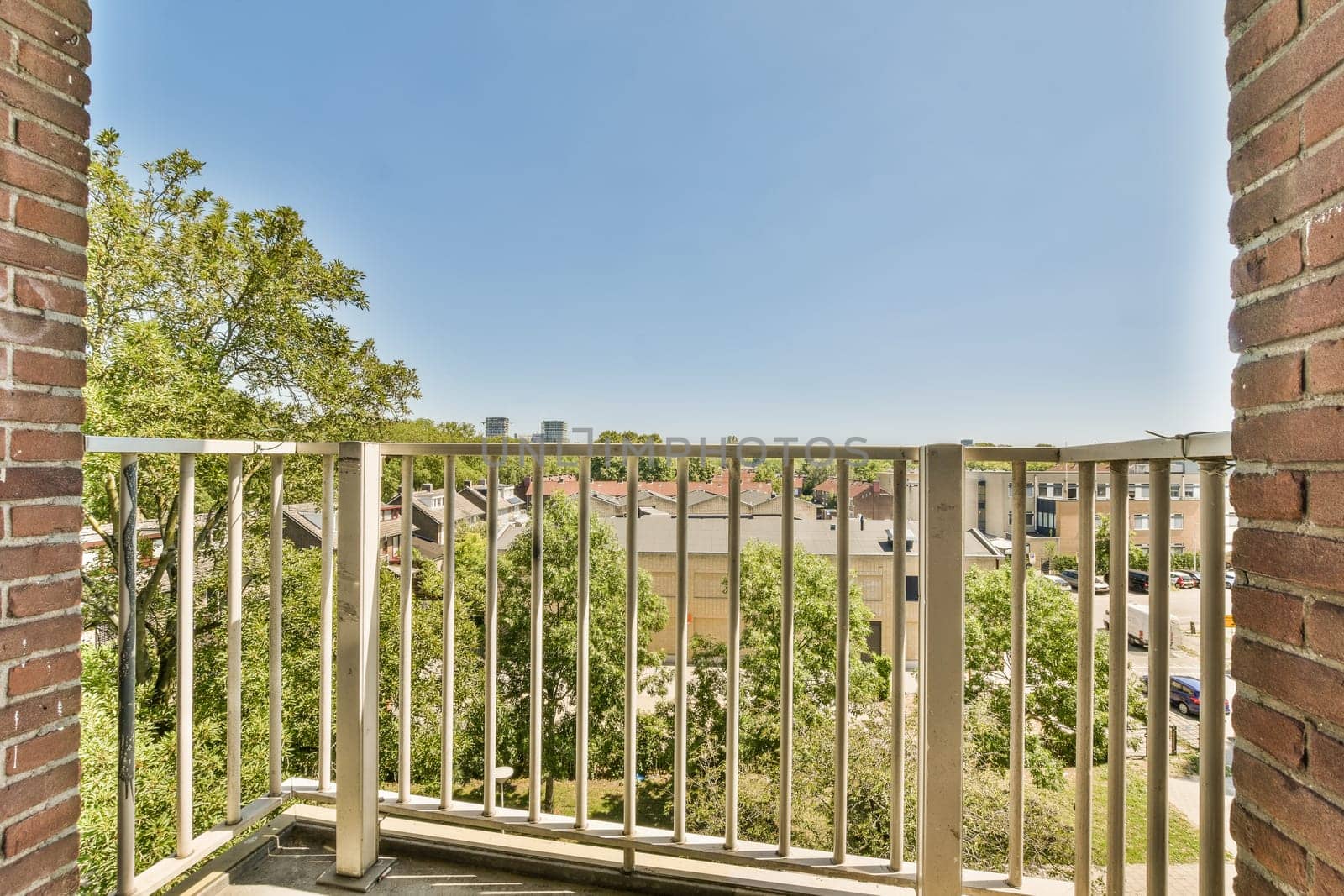 a balcony with a view of a building and trees by casamedia