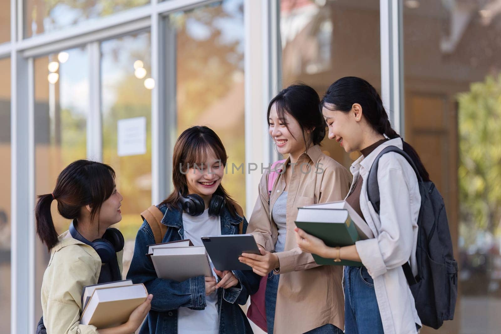 University students reading books and tutoring special class while walking to next class.