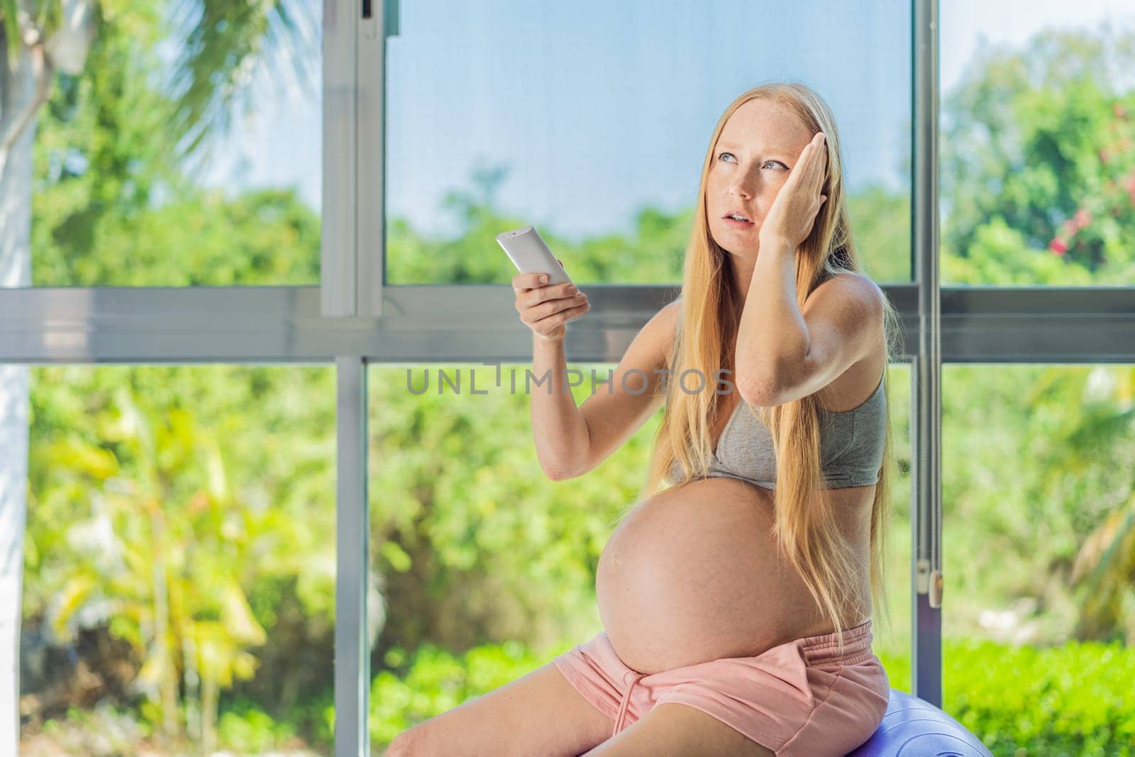 In the midst of a hot day, a pregnant woman finds relief and comfort as she enjoys the cooling embrace of air conditioning, ensuring a soothing and relaxing atmosphere by galitskaya