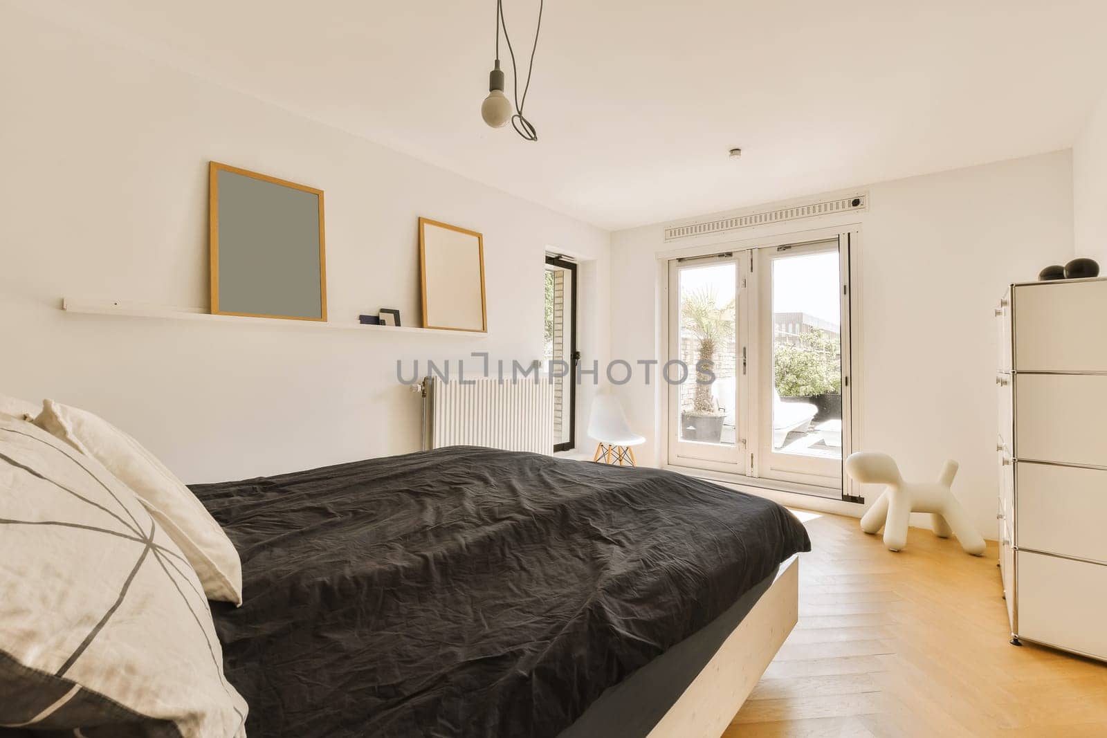 a bedroom with white walls and wood flooring in the fore - image was taken from an insic window